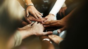 closeup diverse people joining hands